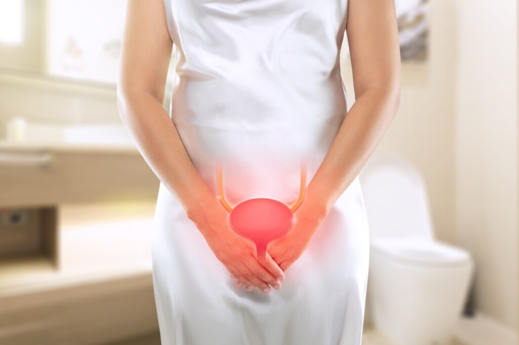 A woman is experiencing the benefits of the MonaLisa Touch procedure as she holds a red ball against her stomach.
