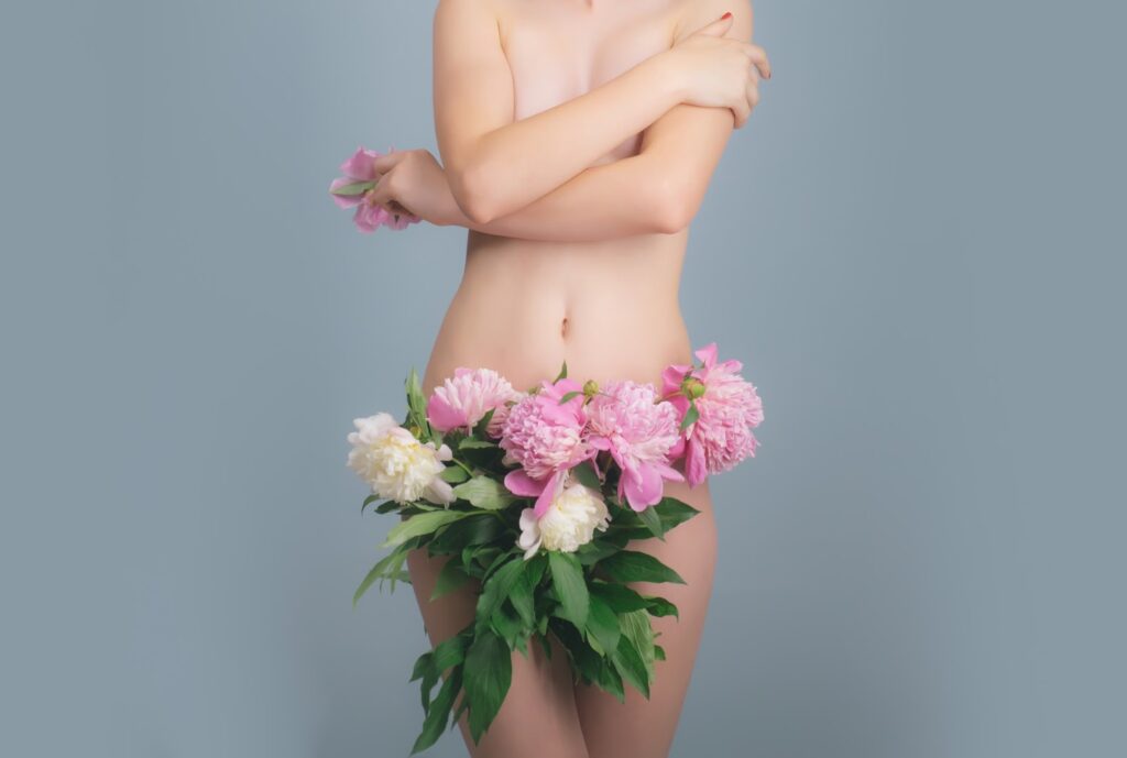 A woman in a bikini gracefully holding a bouquet of flowers.